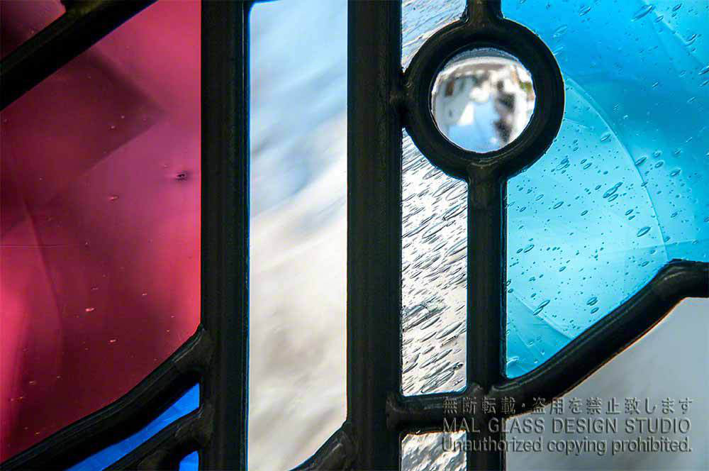 赤紫とブルーとクリアーのアンティークガラスがきれいなステンドグラスの拡大写真。