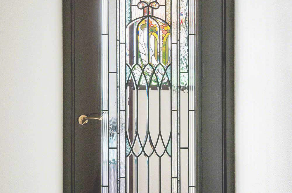 廊下からリビングルームへのドアに取り付けられたアンティーク調のステンドグラスのドア。