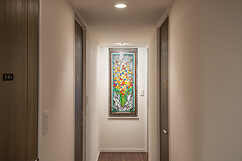 廊下に取りつけた額縁に入ったステンドグラス