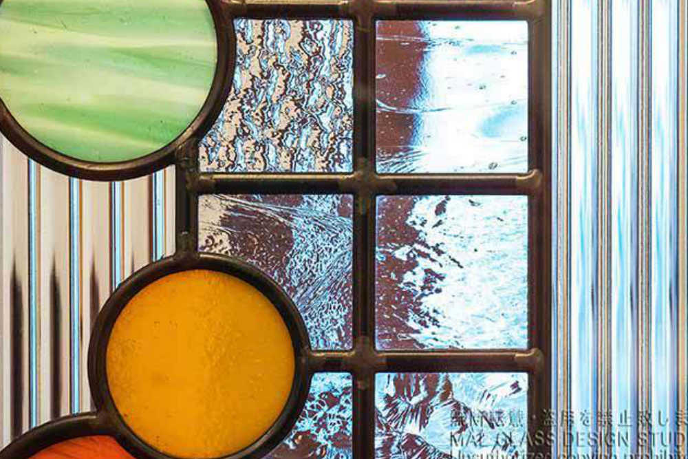 様々な透明ガラスをタイル状に組み合わせたステンドグラスの拡大写真。