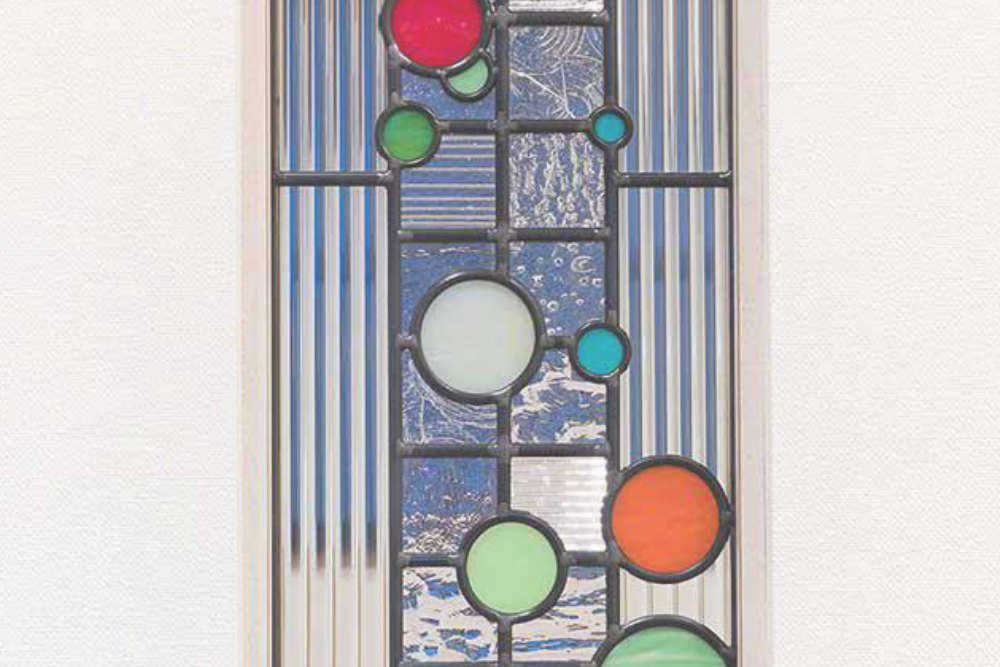 カラフルな色のガラスがリズミカルに跳ねるステンドグラスのクローズアップ写真。