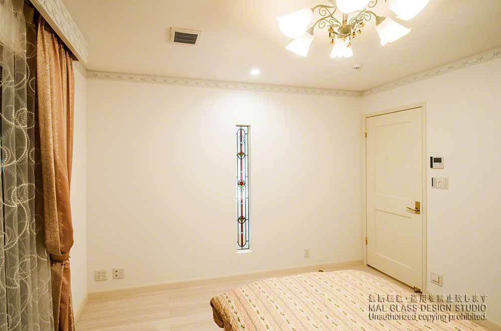 寝室の縦長スリットに施工されたエレガントでかわいいステンドグラス。