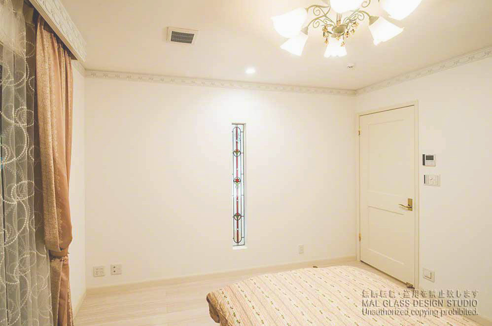 寝室の縦長スリットに施工されたエレガントでかわいいステンドグラス。